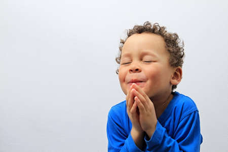 boy praying to god with hands together stock photoの写真素材