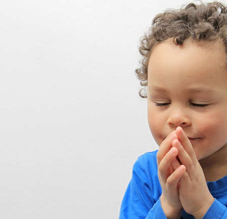 boy praying to god with hands together stock photoの写真素材
