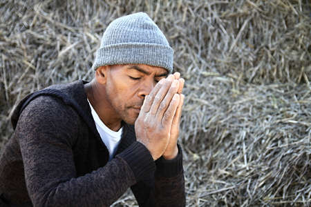 man praying to god with hands together Caribbean man praying stock photoの写真素材