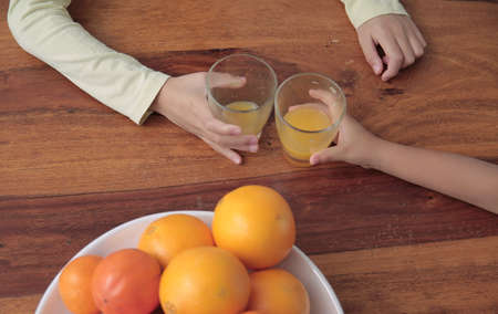 child drinking a glass of orange fruit juice promoting healthy eating stock photo