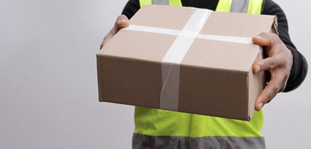 Delivery man with parcel on whiteの写真素材
