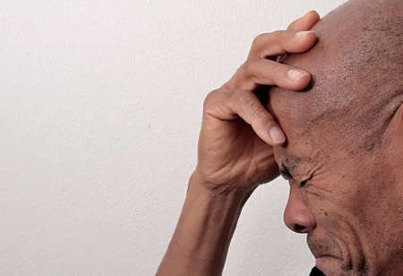 man holding his head suffering from depression on white background stock photo