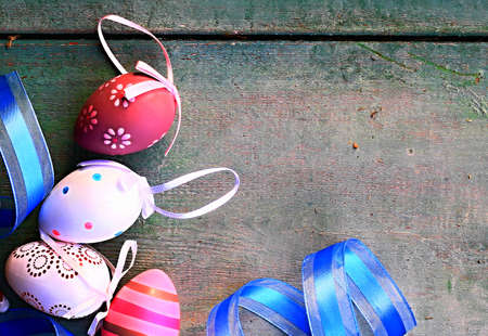 Easter eggs with ribbons on rustic wooden background, top viewの写真素材