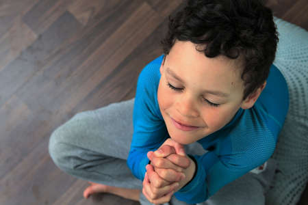 boy praying to God with hands together on white background stock photoの写真素材