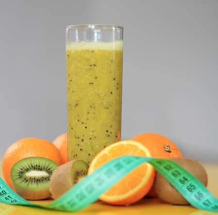 Healthy smoothie with kiwi, orange and tape measureの写真素材