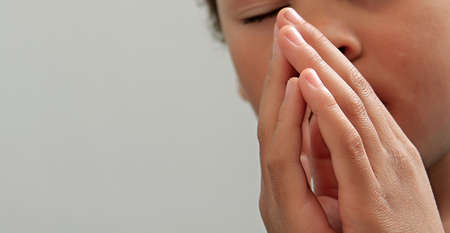 boy praying to God with hands together on white background stock photo
