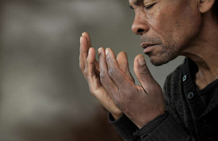man praying to god with hands together with sunset sky stock photoの写真素材
