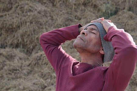 man praying to god with hands together stock photo