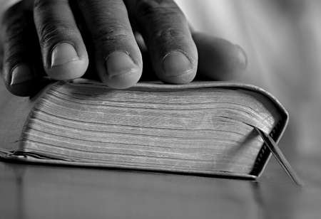 praying to god with hands together on dark background stock photo