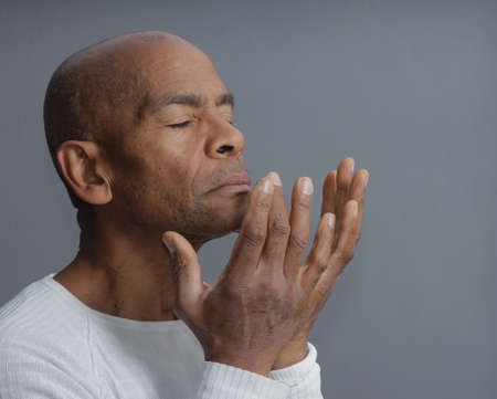 man praying to god with hands together stock photoの写真素材