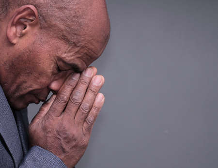 man praying to god with hands together stock photoの写真素材