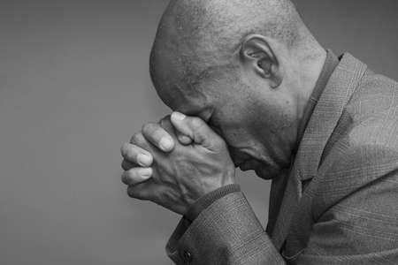 man praying to god with hands together on grey background stock photoの写真素材