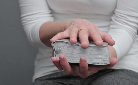 woman praying to God with bible on gray background stock photoの写真素材