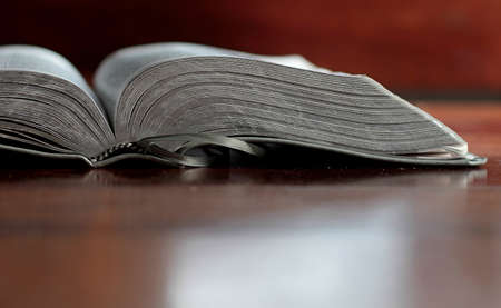 Open book on a wooden table. Close-up. Selective focus.の写真素材