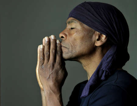 man praying to god with hands together on grey background stock photoの写真素材