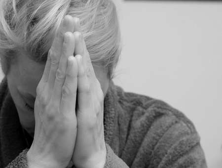 woman praying with hands together stock photo