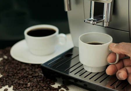 Close-up of a man's hand holding a cup of coffeeの写真素材