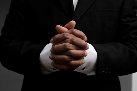 man praying to god with hands together Caribbean man praying with black background stock photos stock photoの写真素材
