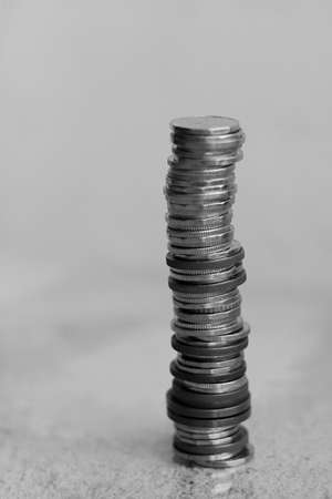 Stacks of coins on a gray background. Black and white photo.の写真素材