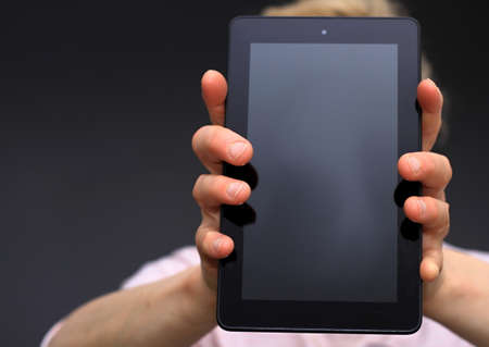 A man holds a tablet in his hands. Close-up.の写真素材