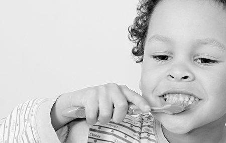 Cute little boy brushing his teeth on white background, closeupの写真素材