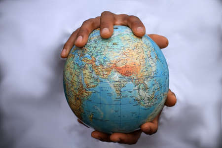 Hand holding a globe on a white background.の写真素材
