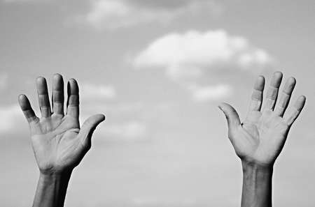 Black and white image of male hands on the background of the sky