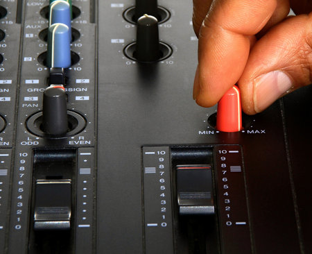 Sound mixer control panel, closeup of hands with red nail polishの写真素材