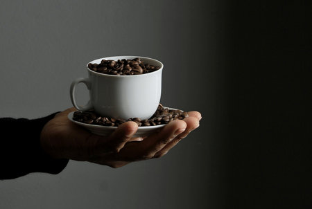 Coffee beans in a white cup on a dark background.の写真素材