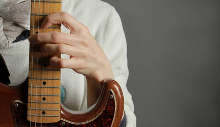 Young woman playing on electric guitar, close-up. Music conceptの写真素材