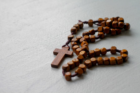 Wooden rosary beads with cross on a white background.の写真素材
