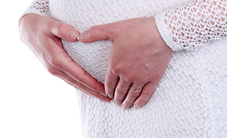 Pregnant woman holding her hands on her belly, isolated on whiteの写真素材