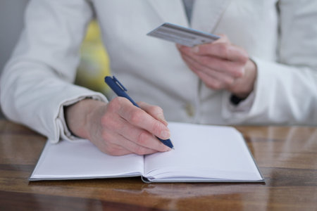 Close-up of a woman writing in notebookの写真素材