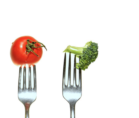 Tomato and broccoli on a fork isolated on a white background.の写真素材