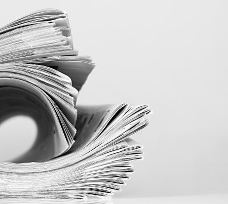 Stack of newspapers on white background, close-up, monochromeの写真素材