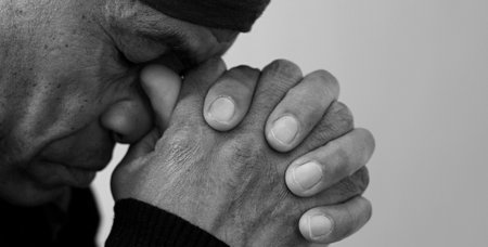man praying to god with hands together Caribbean man praying with black background stock photos stock photoの写真素材