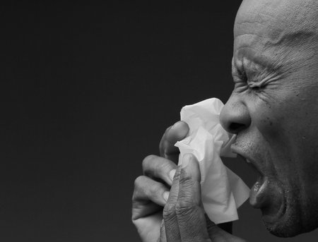 blowing nose after catching the cold and flu with grey background with people stock image stock photoの写真素材