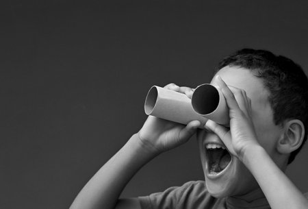 boy looking  through binoculars on grey background with people stock image stock photoの写真素材