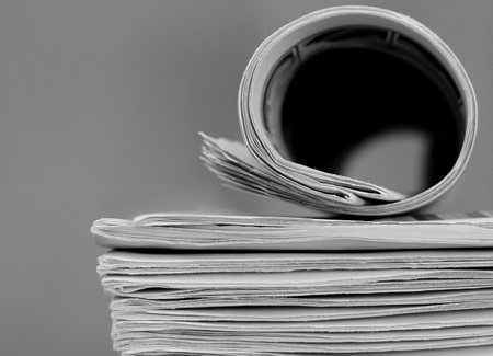 newspaper rolled up and sitting on a table no people stock image stock photoの写真素材