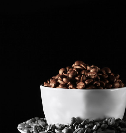 Coffee beans in a white bowl on a black background.の写真素材