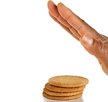 Hand reaching for a stack of cookies isolated on a white background.の写真素材