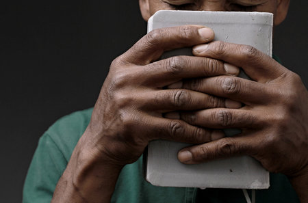 praying to God with the bible on black background with people stock image stock photoの写真素材