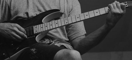 Close up of a man playing electric guitar. Black and white.の写真素材