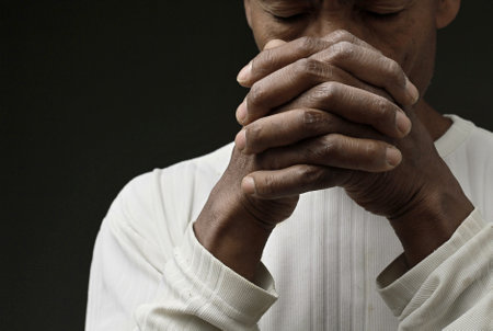black man praying to god on gray background with people stock image stock photo