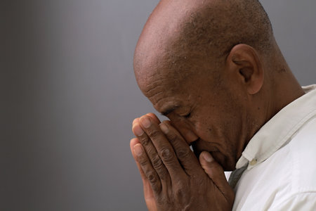 black man praying to god on gray background with people stock image stock photoの写真素材