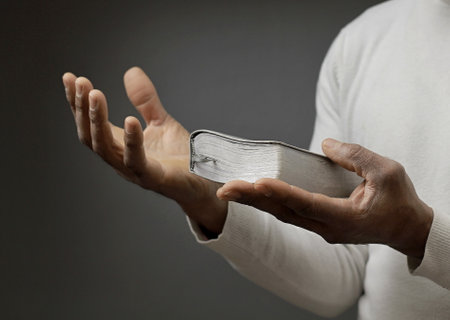 man praying with bible with grey black background with people stock image stock photoの写真素材
