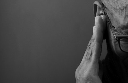 deafness suffering from hearing loss on grey black background with people stock image stock photoの写真素材