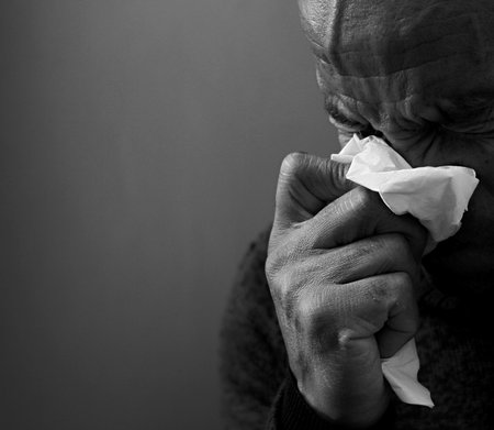 blowing nose after catching the cold and flu with grey background with people stock image stock photoの写真素材