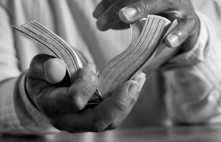 man praying with bible with grey black background with people stock image stock photoの写真素材