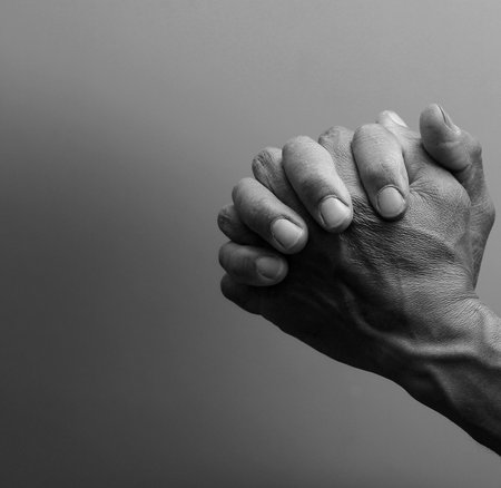 man praying with bible with grey black background with people stock image stock photo